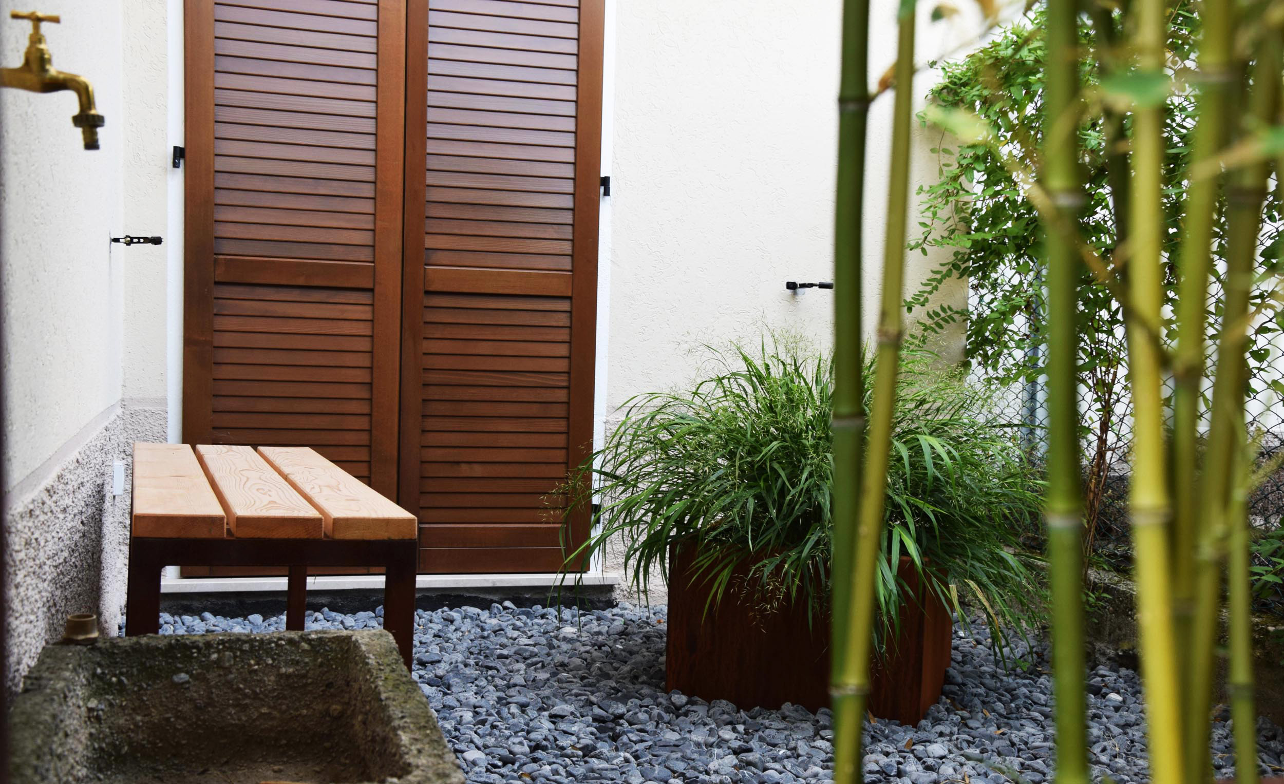 spazio outdoor, ciottoli grigi, Phyllostachys bissetii, seduta in acciaio corten, vasca in acciaio corten, hakonechloa macra 