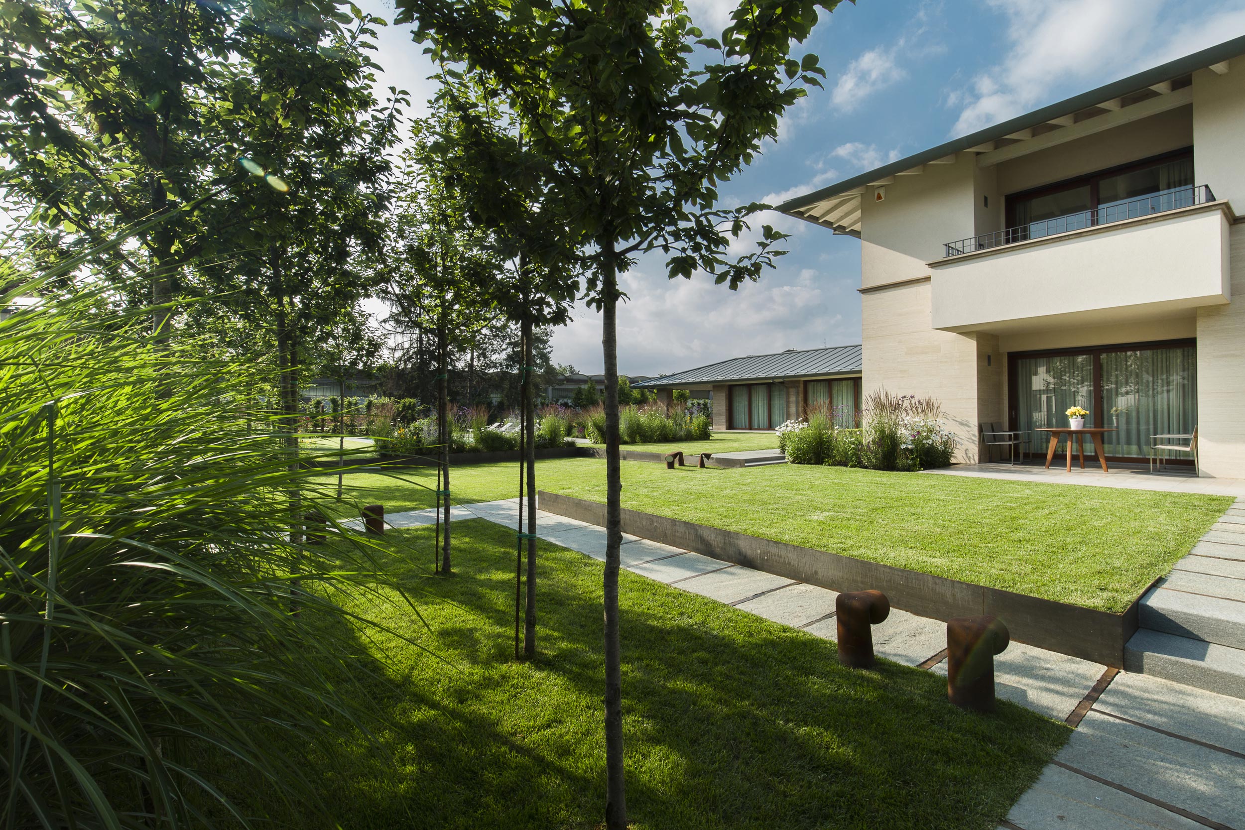 terrazzamento, lamiere in acciaio corten, aiuole con erbacee perenni e graminacee, micro boschetti di Prunus padus